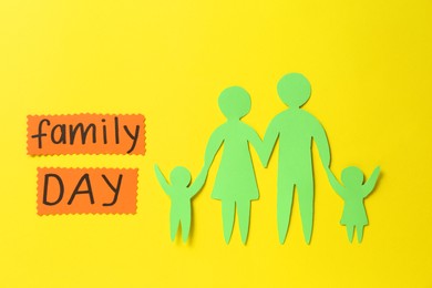 Cards with text Family Day and paper cutout on yellow background, flat lay