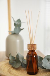 Reed diffuser and home decor on wooden tray indoors
