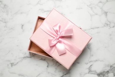 Beautiful pink gift box on white marble table, top view