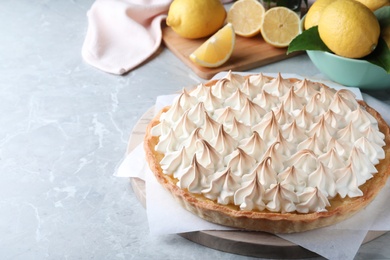 Delicious lemon meringue pie on light grey table, space for text