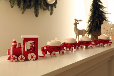 Red toy train as Christmas candle holder on shelf
