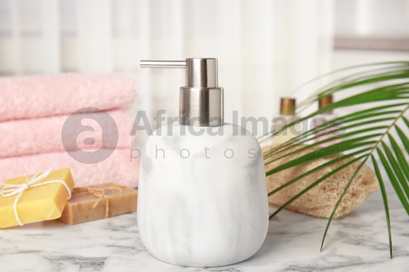 Marble dispenser, soap bars and luffa sponge on table