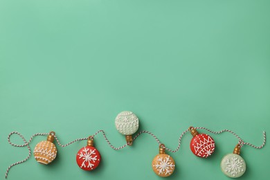 Beautifully decorated Christmas macarons with rope on turquoise background, flat lay. Space for text