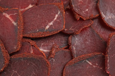 Delicious dry-cured beef basturma slices as background, top view