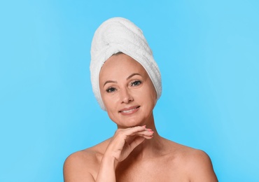 Photo of Portrait of beautiful mature woman with perfect skin on light blue background