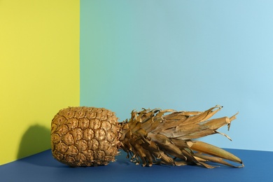 Photo of Golden pineapple on color background, space for text. Creative concept
