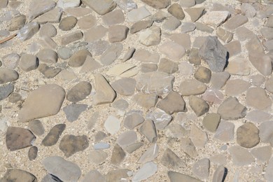 Surface of ground with different grey stones as background, above view