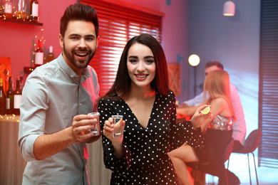 Photo of Young couple with Mexican Tequila shots in  bar