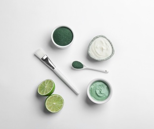 Photo of Composition with spirulina facial mask and ingredients on white background, top view