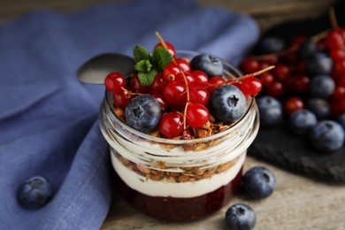 Delicious yogurt parfait with fresh berries and mint on table, closeup