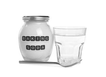 Jar and spoon with baking soda near glass of water on white background