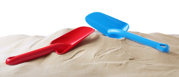 Photo of Light blue and red plastic toy shovels on pile of sand