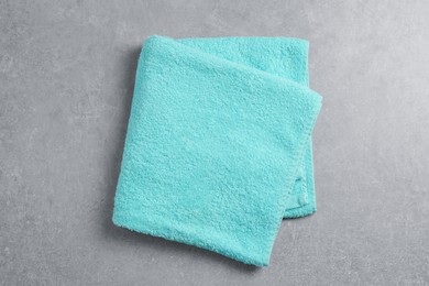 Soft folded towel on gray background, top view