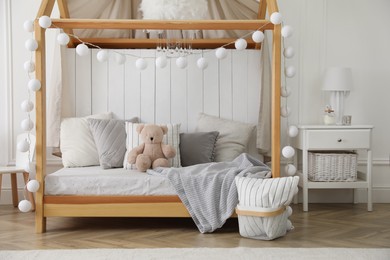 Photo of Stylish room for kid with house bed. Interior design