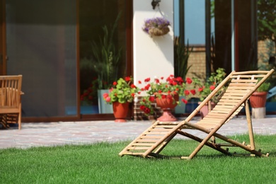 Photo of Wooden deck chair in beautiful garden on sunny day. Space for text