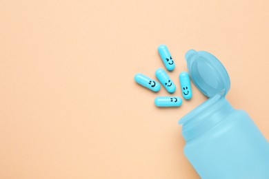 Photo of Bottle and antidepressant pills with funny faces on pale orange background, flat lay. Space for text