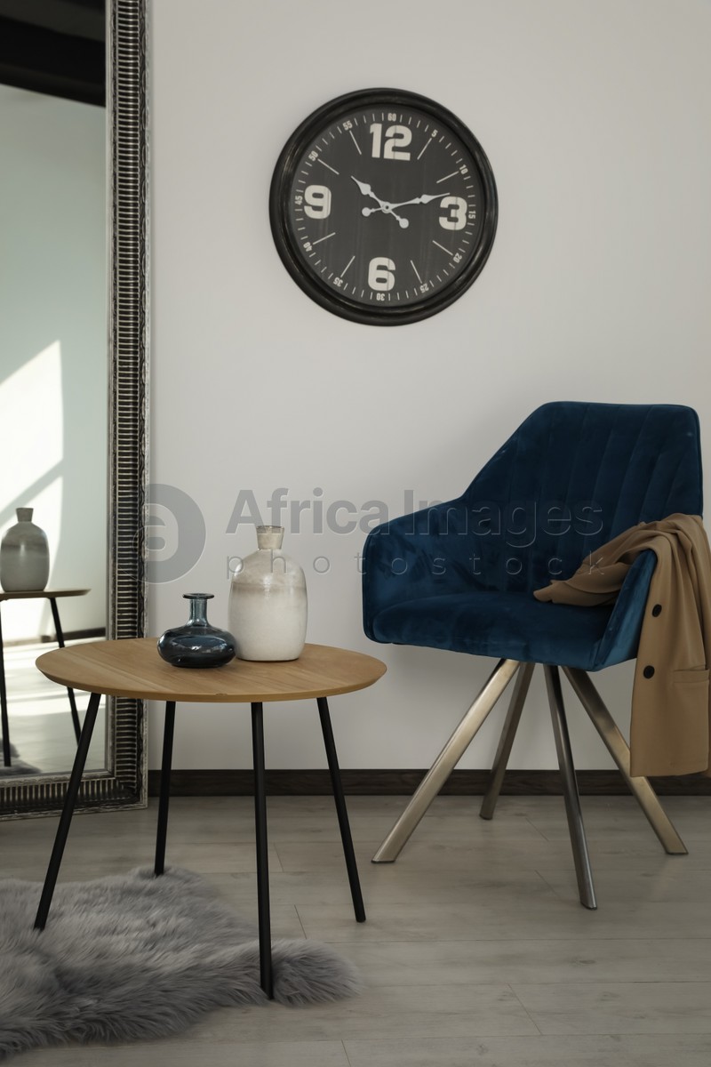 Photo of Room with wooden table and blue armchair. Stylish interior
