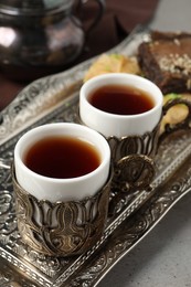 Photo of Tea served in vintage tea set on grey table, closeup