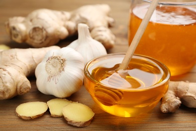 Ginger, garlic and honey on wooden table. Natural cold remedies