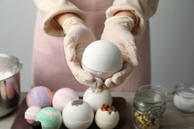Woman in gloves with self made bath bomb at table, closeup