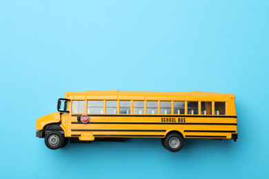 Yellow school bus on light blue background, top view with space for text. Transport service
