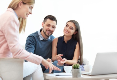 Female real estate agent working with couple in office