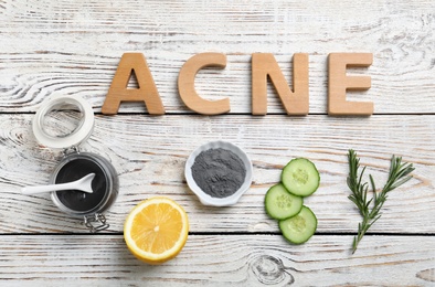 Word "Acne" and fresh ingredients for homemade problem skin remedy on wooden background