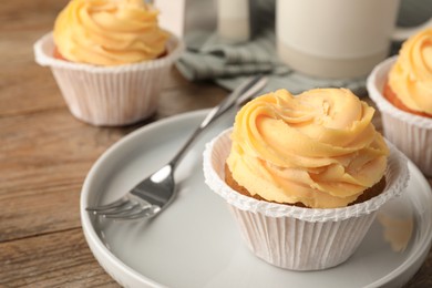 Tasty cupcakes with cream served on table, closeup