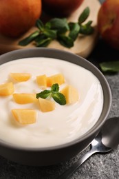 Delicious yogurt with fresh peach and mint on grey table, closeup