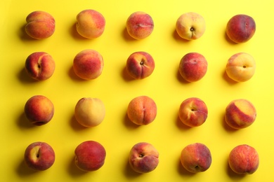 Fresh ripe peaches on yellow background, flat lay