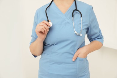 Photo of Professional doctor with stethoscope indoors, closeup view