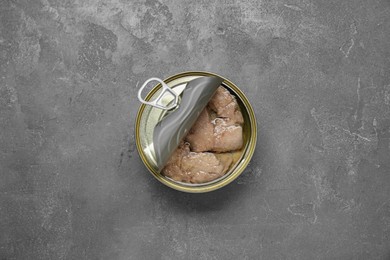 Photo of Open tin can of tasty cod liver on grey table, top view