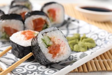 Tasty sushi rolls with wasabi served on table, closeup