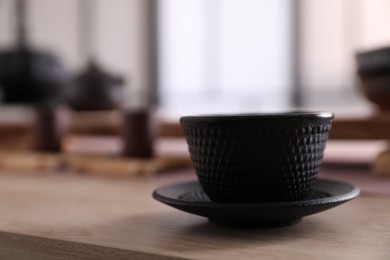 Cup with saucer for traditional tea ceremony on wooden table
