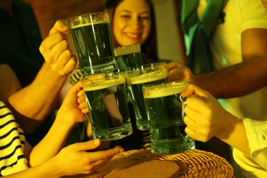 People with beer celebrating St Patrick's day in pub, closeup