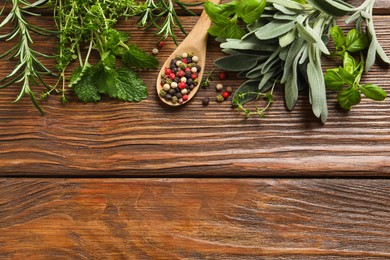 Different fresh herbs and spices on wooden table, flat lay. Space for text