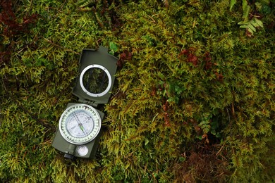Compass on moss, above view. Space for text