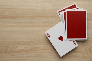 Photo of Deck of playing cards on wooden table, flat lay. Space for text