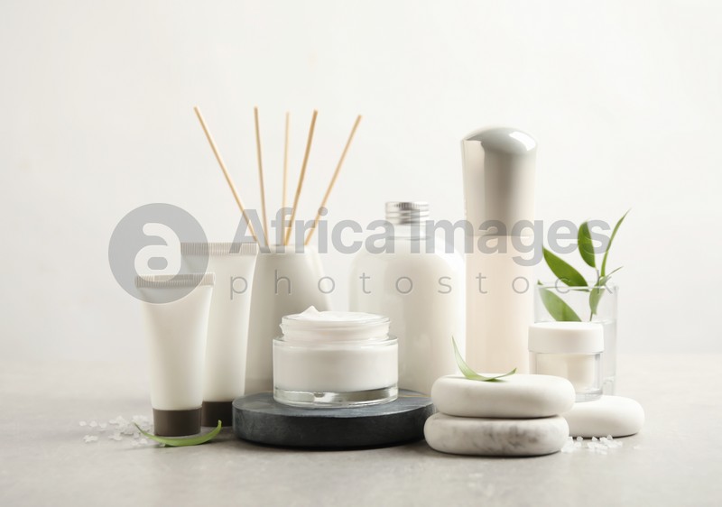 Composition with skin care products and spa stones on light background