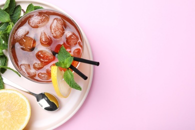 Delicious iced tea with lemon and mint on pink background, top view. Space for text