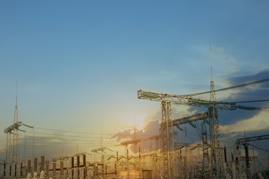 Modern electrical substation against cloudy sky at sunset