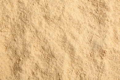 Dry powdered ginger as background, top view