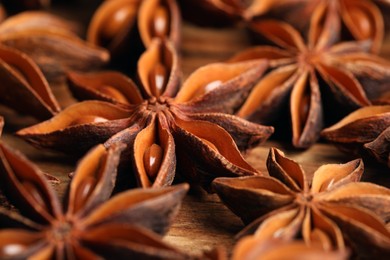 Aromatic anise stars on wooden table, closeup