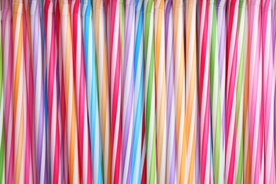 Heap of colorful plastic straws for drinks as background, closeup