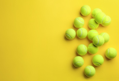 Tennis balls on yellow background, flat lay. Space for text