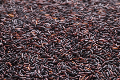 Uncooked organic brown rice as background, closeup