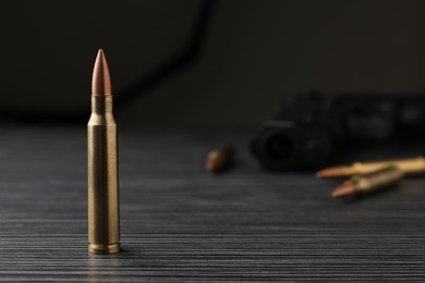 Bullet on black wooden table. Space for text