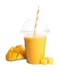 Photo of Plastic cup of tasty mango smoothie and fresh fruit on white background