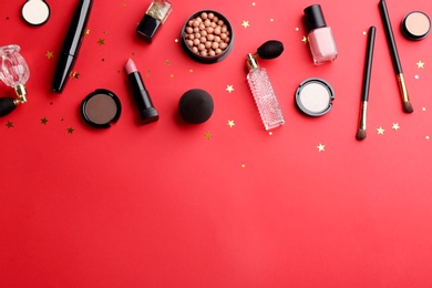 Flat lay composition with decorative cosmetic products on red background, space for text. Winter care