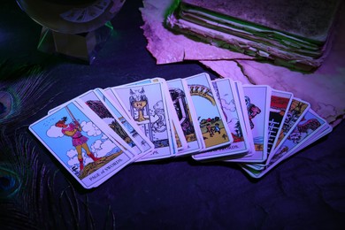 Page of Swords and other tarot cards on dark table, color toned